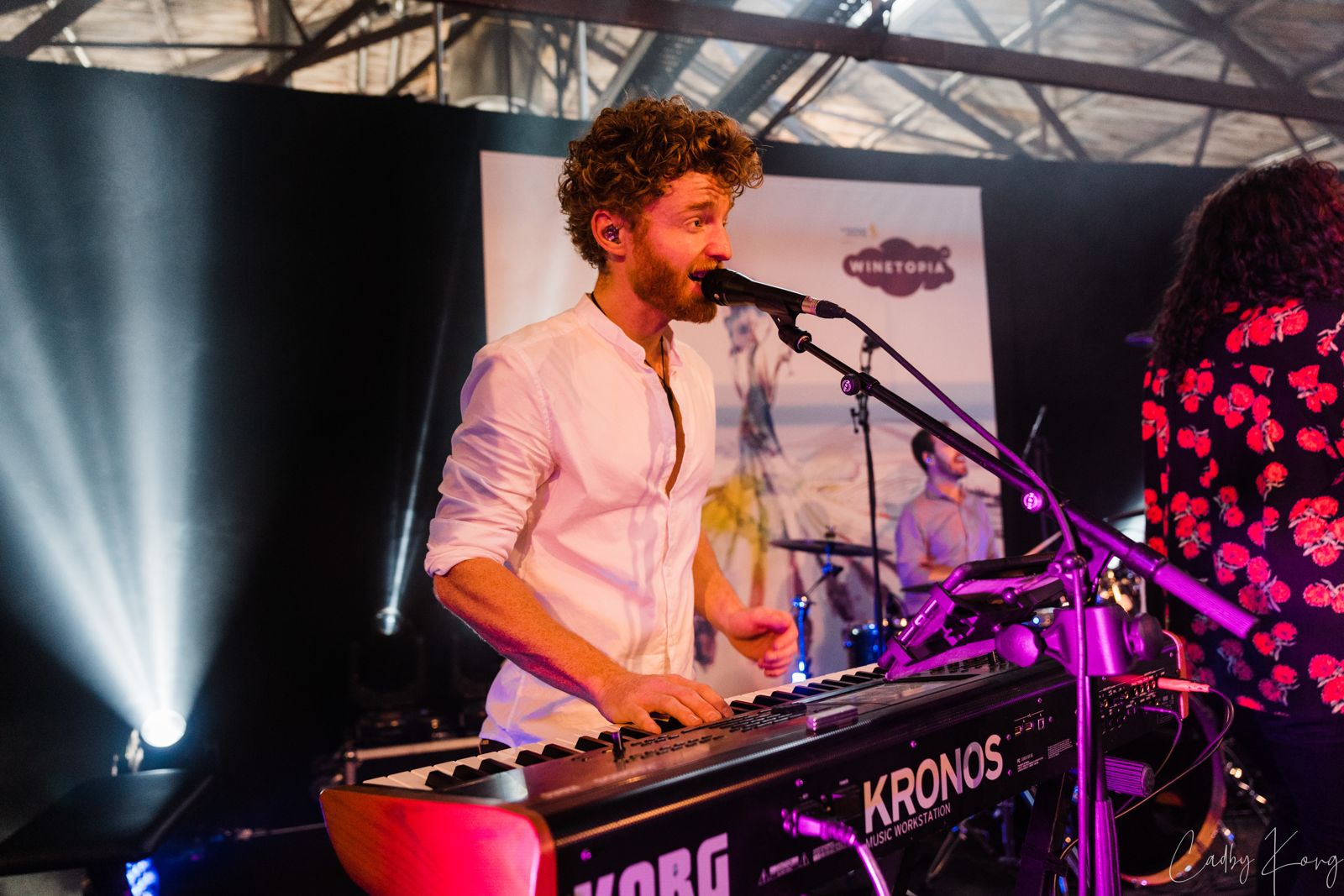 Keyboard player singing at a red Korg Kronos